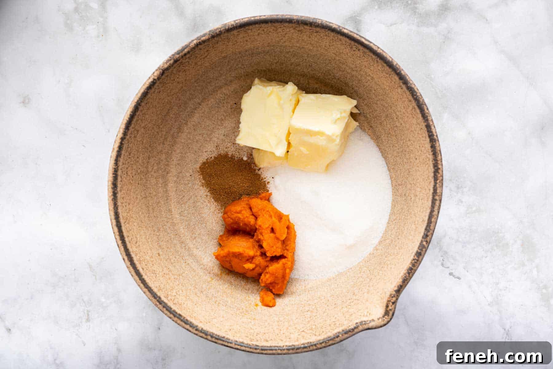 Tan bowl with super soft butter, pumpkin, sugar and spices.