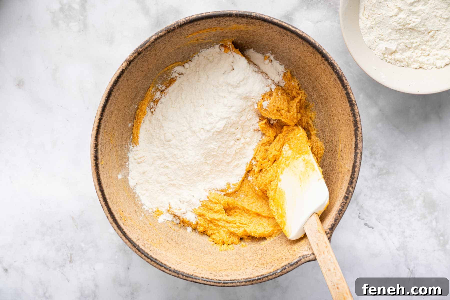 Orange batter with flour on top.