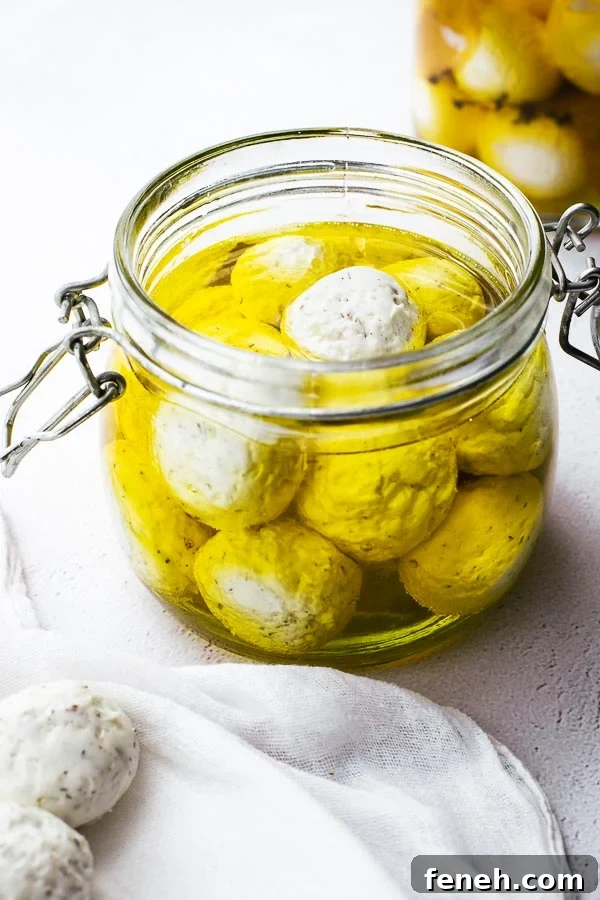 Garlic and herb labneh balls in a jar of olive oil.