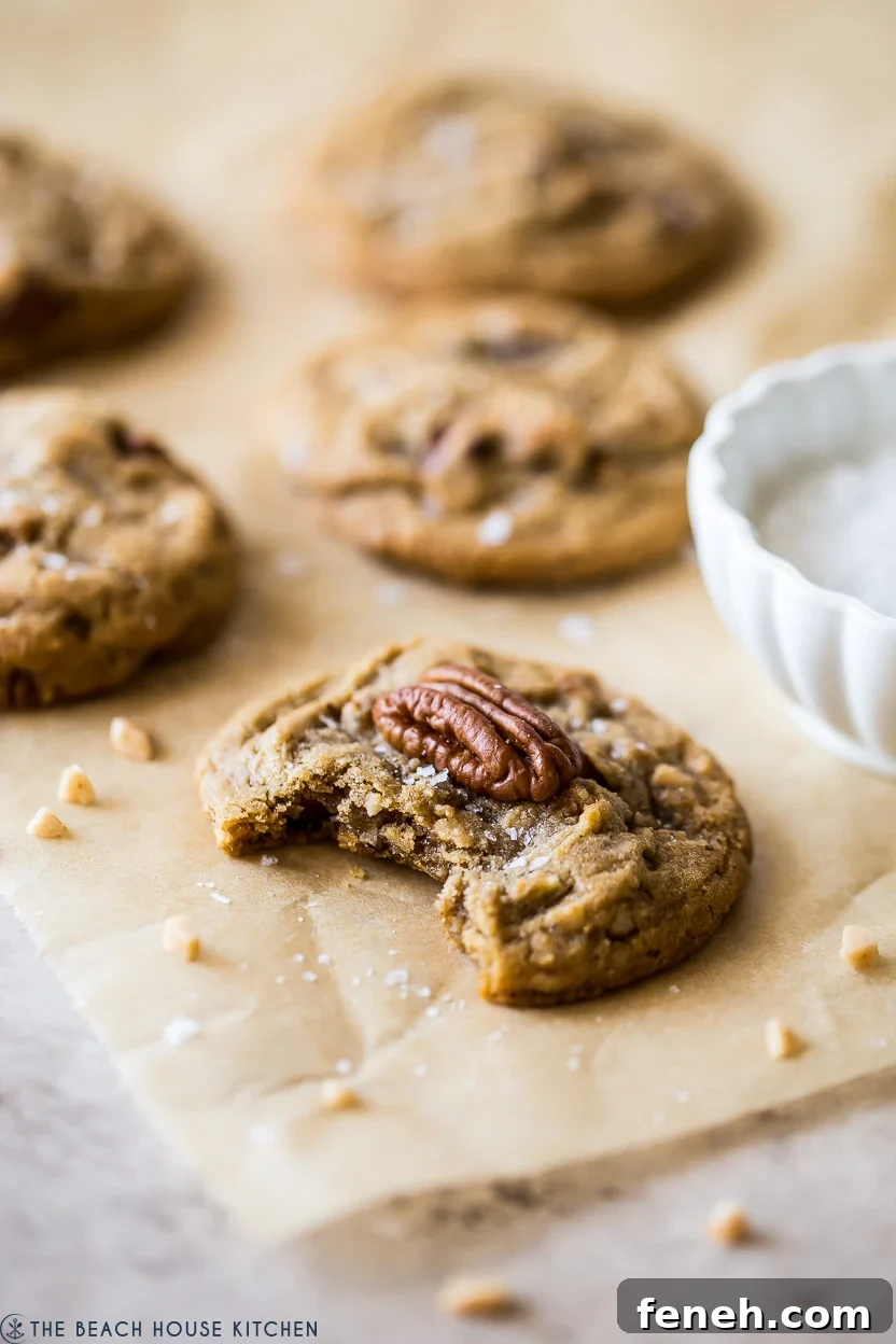 Up close photo of a cookie topped with a pecan halve