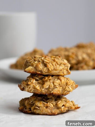 three banana breakfast cookies stacked with a plate of cookies behind