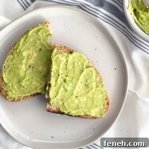 3-Ingredient Dunkin’ Style Avocado Toast Recipe 15 Avocado toast with flaky sea salt and cracked black pepper on a white plate