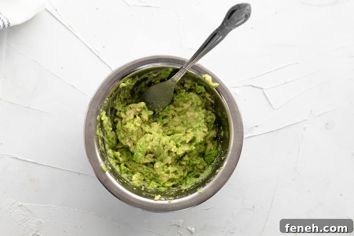 3-Ingredient Dunkin’ Style Avocado Toast Recipe 6 mashed avocado in bowl with a fork