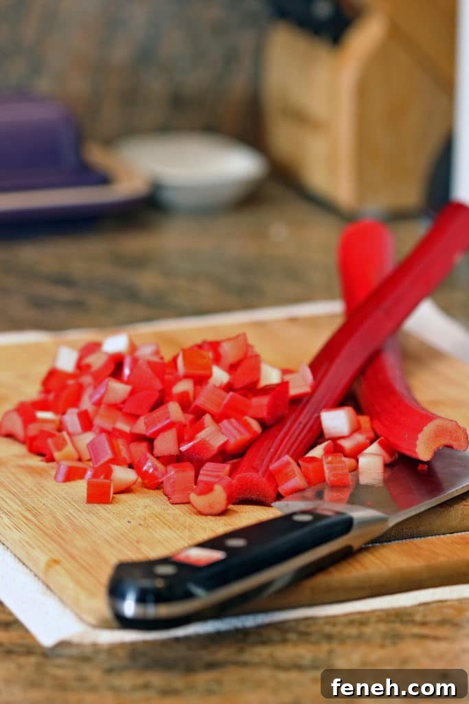 closeup side view: cutting board with knife and diced rhubarb