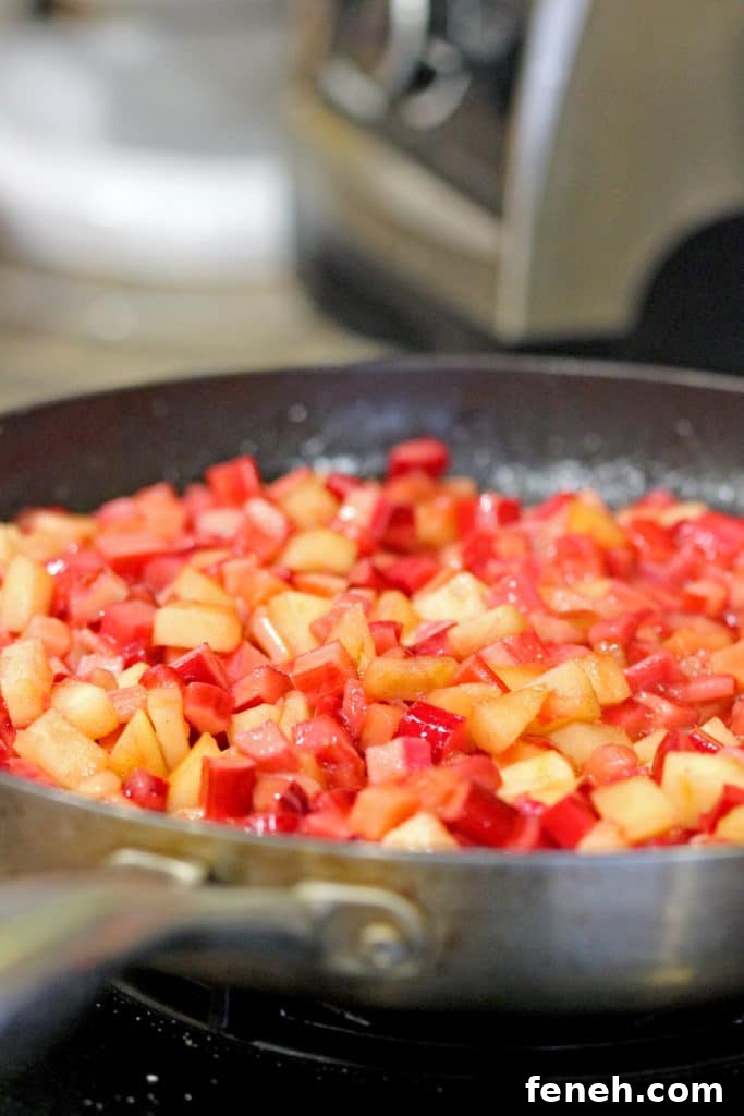 closeup side view: rhubarb, apples, sugar, lemon zest and juice in a sauté pan