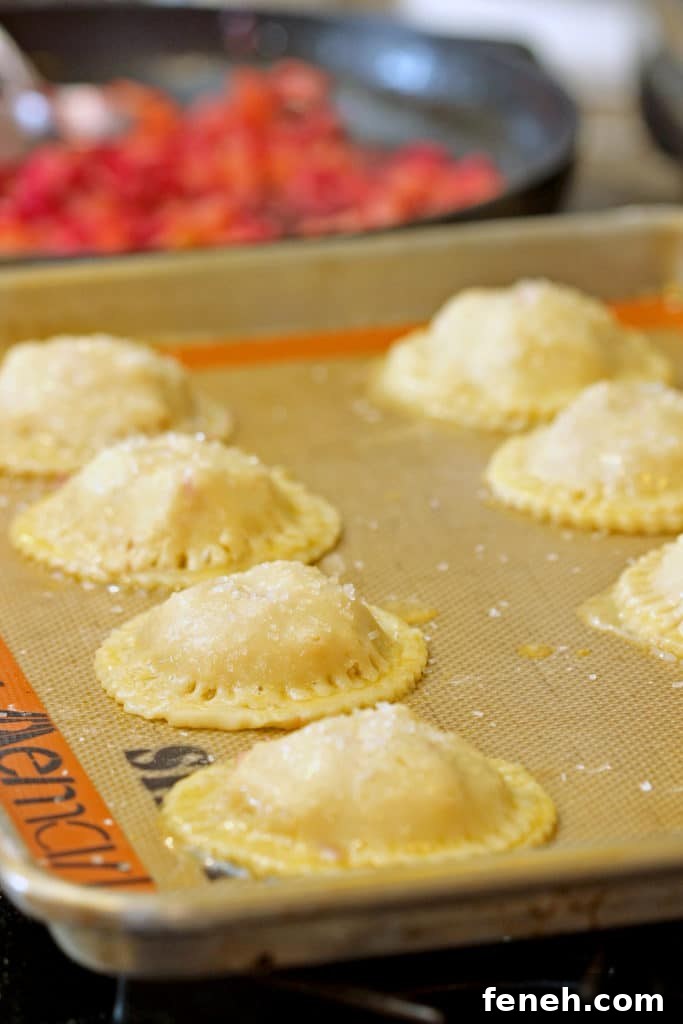 closeup side view: ready to bake rhubarb hand pies on baking sheet