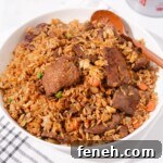 A bowl of beef fried rice with sha cha sauce.