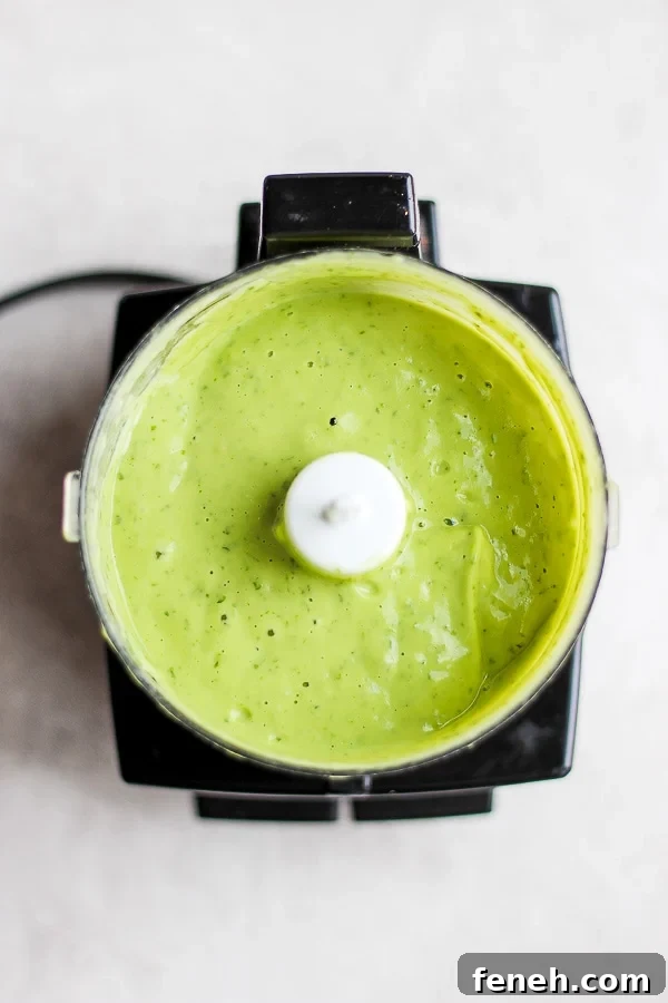The creamy avocado sauce in a small food processor.
