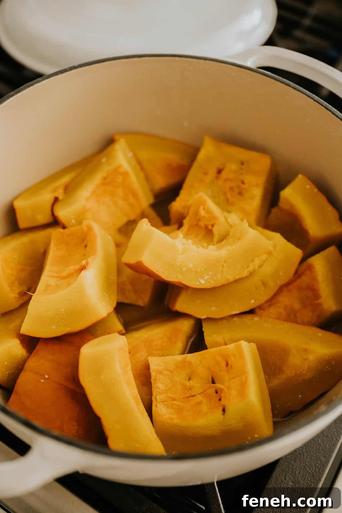 Fresh pumpkin pieces steaming in a pot.