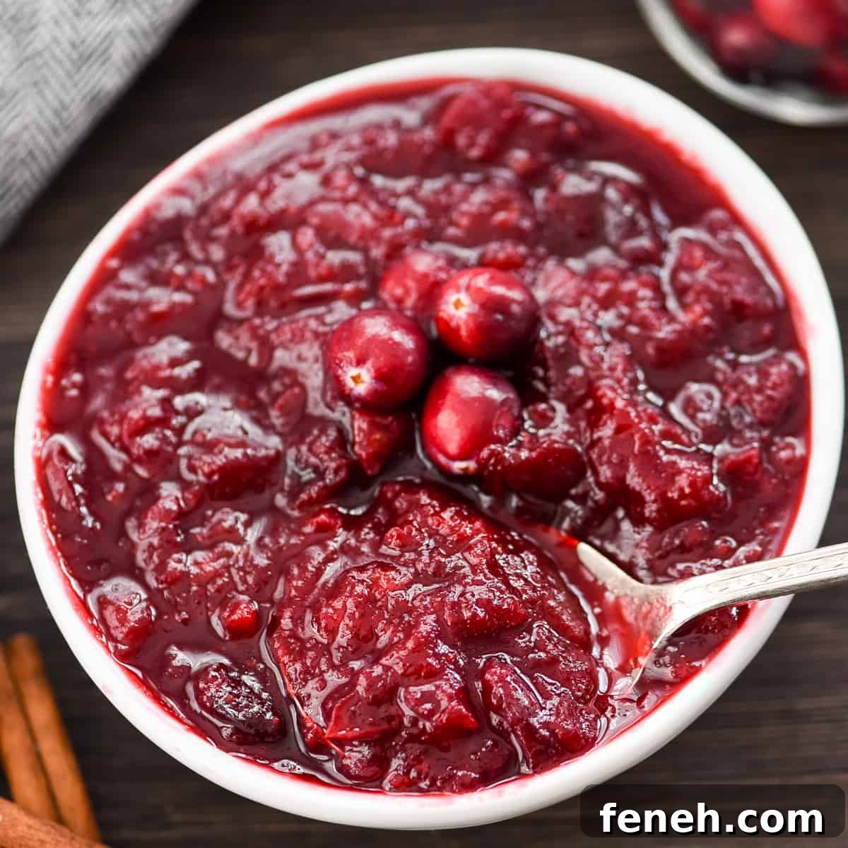 overhead view of a bowl of Healthy Cranberry Sauce with a spoon in it