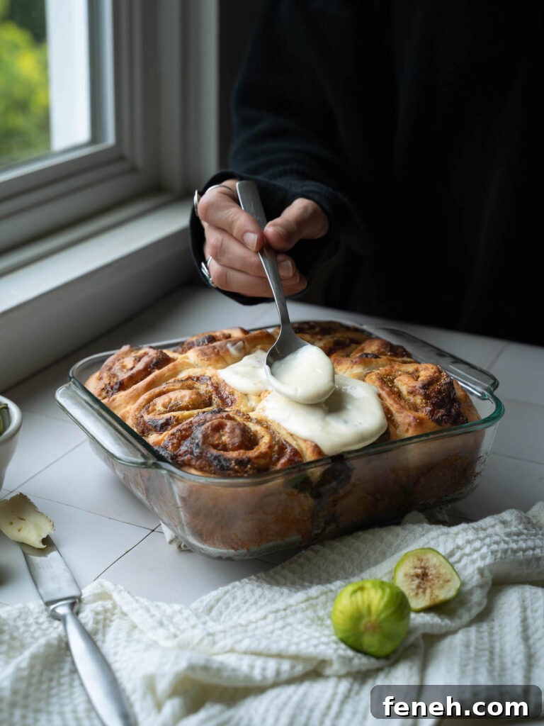 Topping fig cinnamon rolls with honey cream cheese frosting