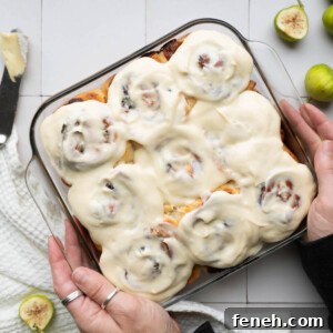 A pan of freshly frosted fig & brie cinnamon rolls
