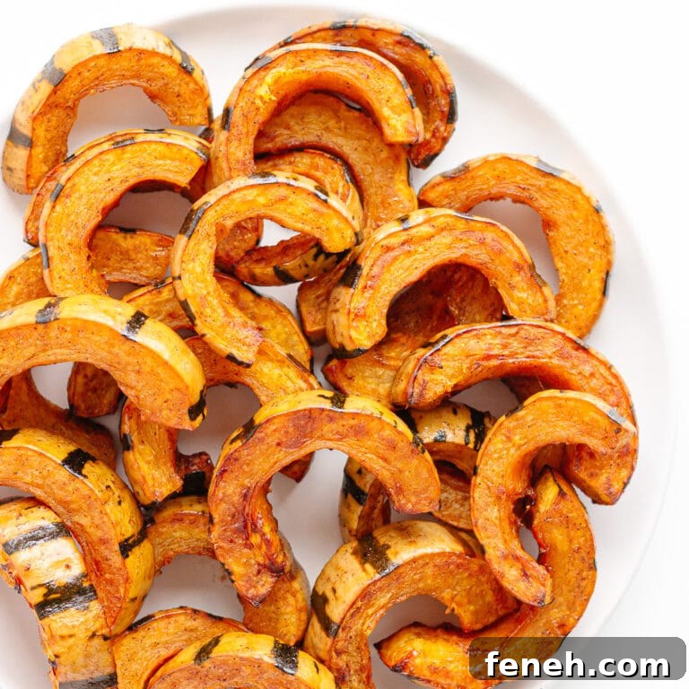 Roasted delicata squash slices on a white serving plate.