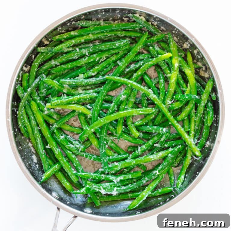 Garlic butter green beans in stainless steel skillet.