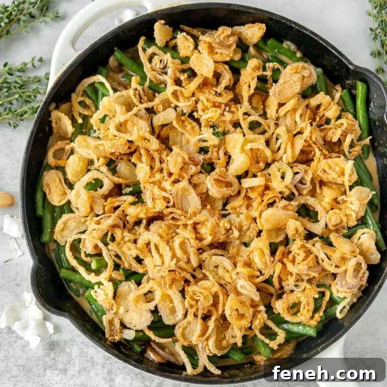 Green bean casserole in a cast iron skillet topped with crispy shallots.