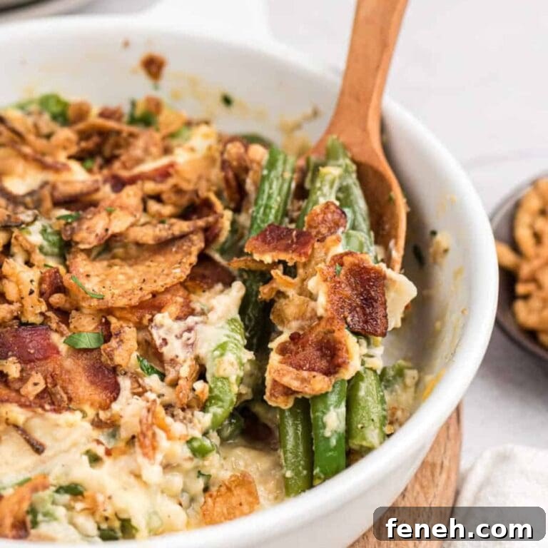 Creamy green bean casserole with bacon in a white serving dish.