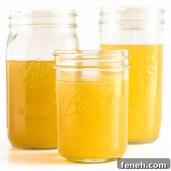Three mason jars of turkey bone broth displayed on a white background.
