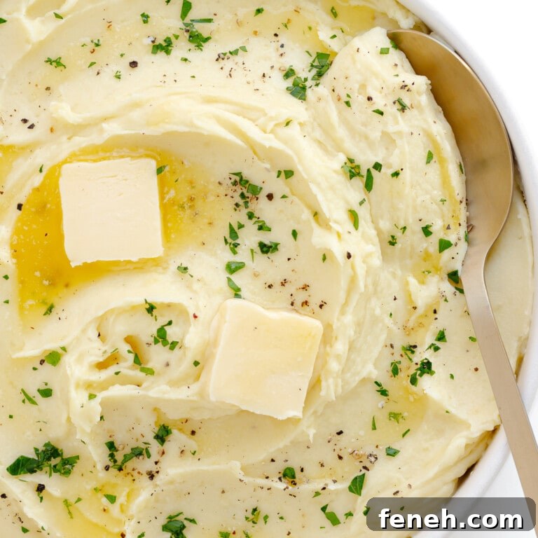 Creamy whipped mashed potatoes in a serving bowl with serving spoon.