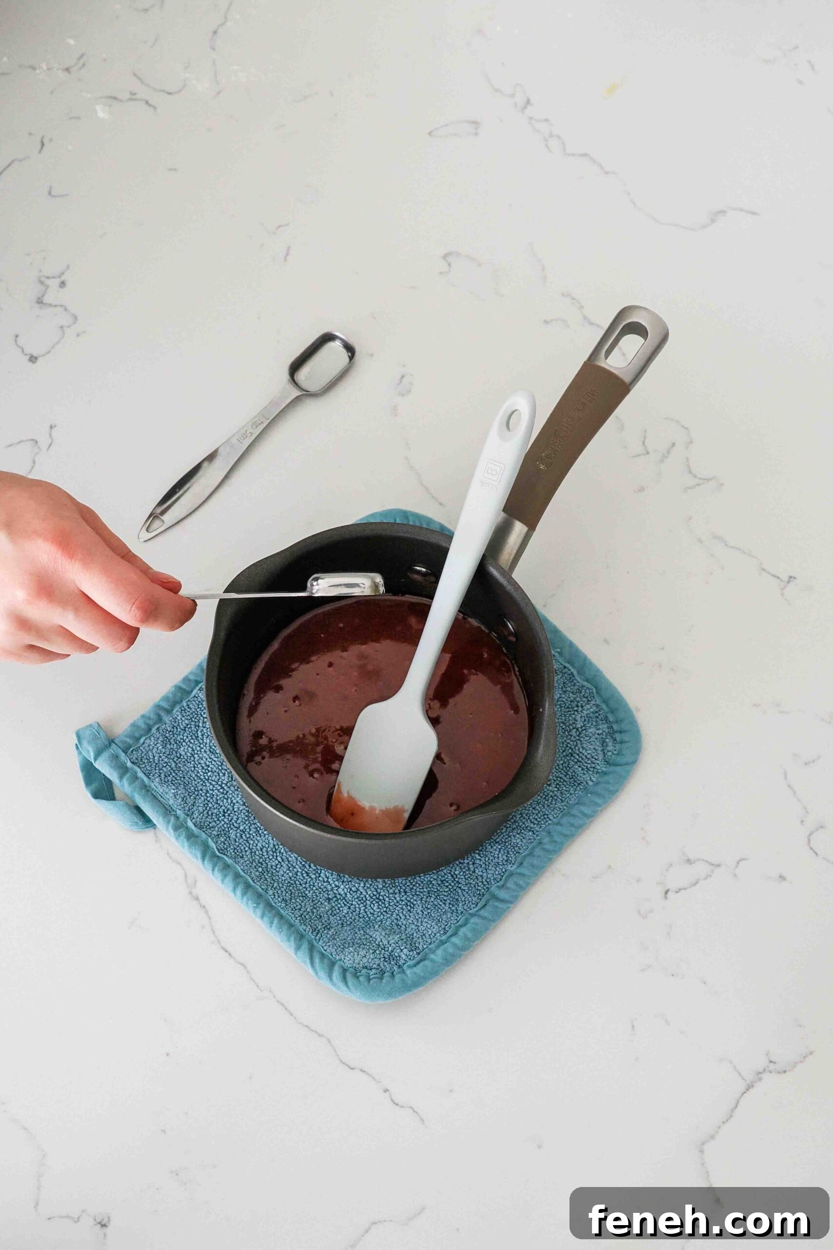 Extract is added to red cherry filling in a saucepan.