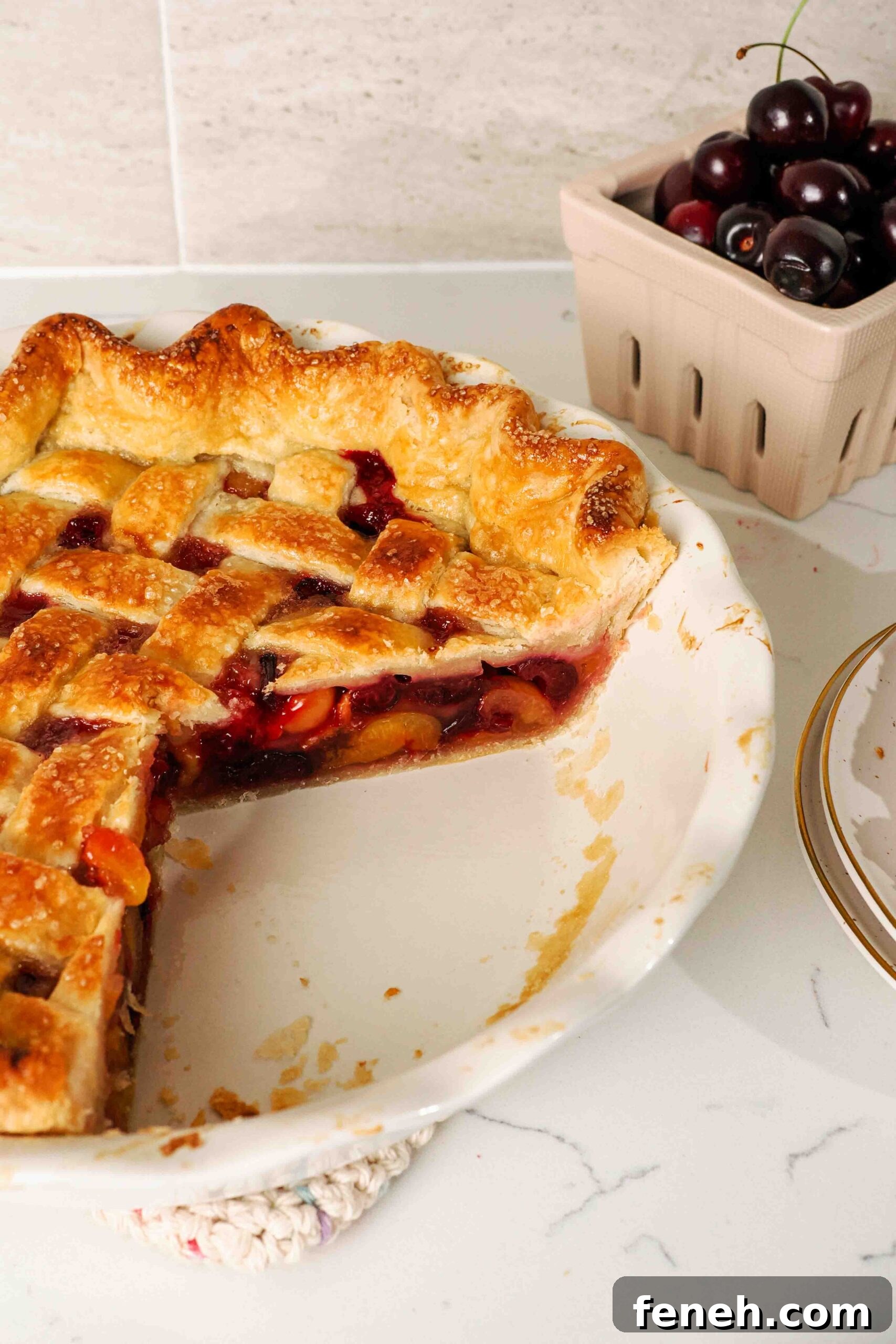 A quarter of a cherry pie is missing from a pie pan.