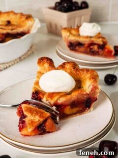 A fork removes the first bite of a slice of cherry pie.