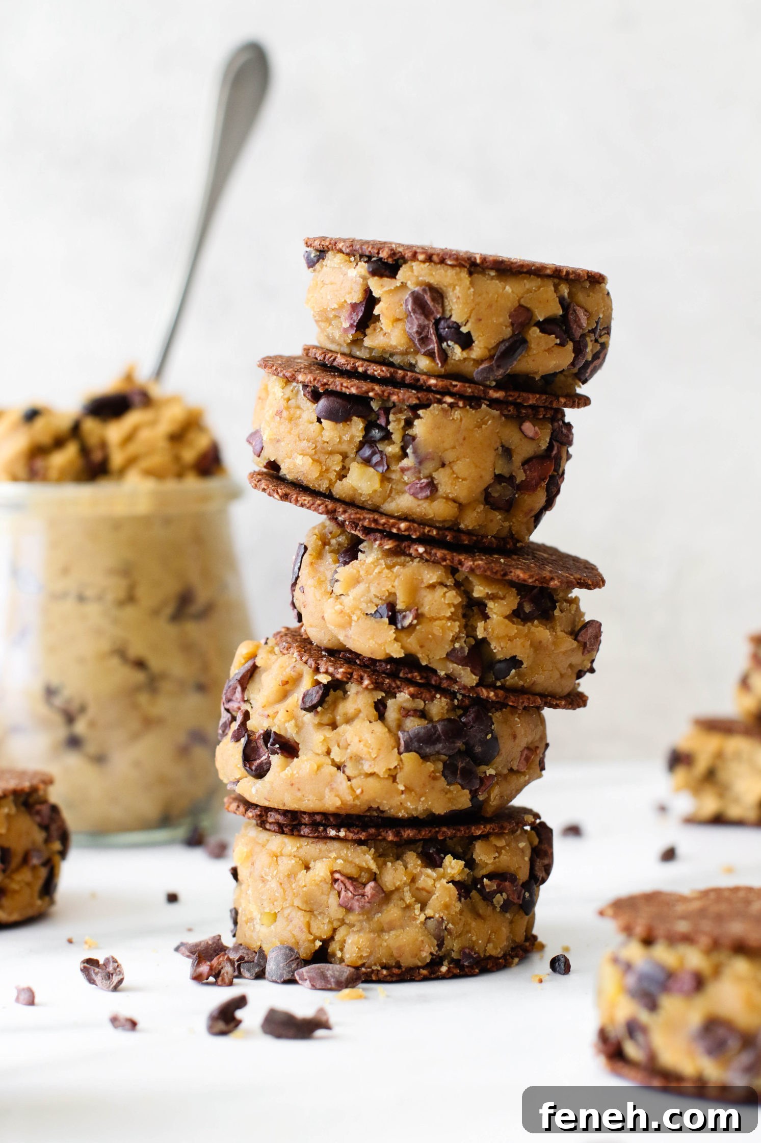 Cacao Chickpea Cookie Dough smashed between cookies and stacked 