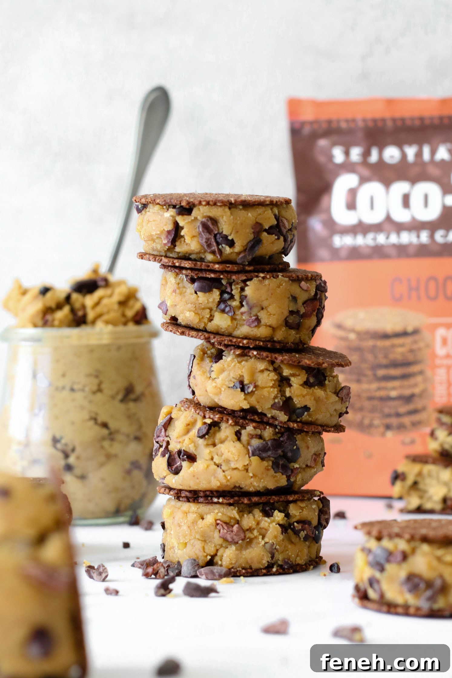 Cacao Chickpea Cookie Dough smashed between cookies and stacked 