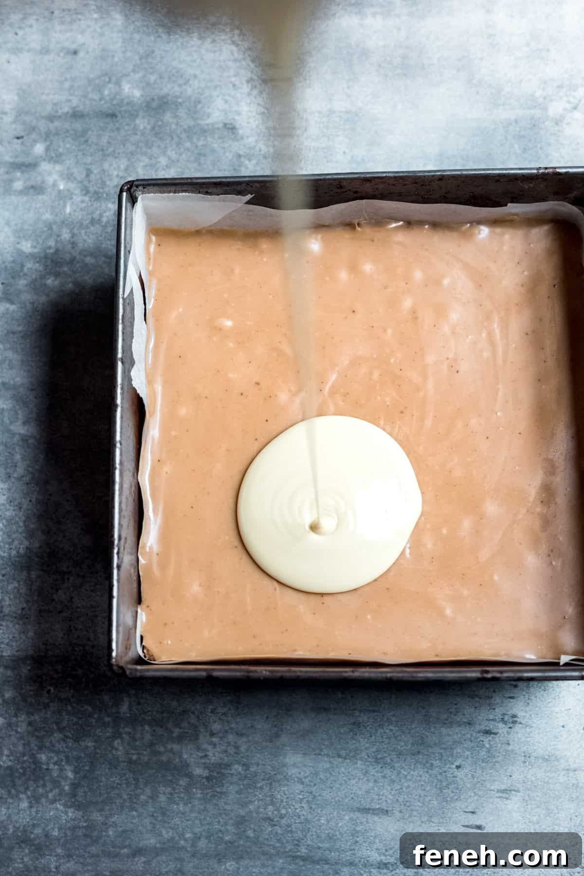 white chocolate being poured over the caramel