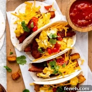 Tray of Breakfast tacos loaded with eggs, bacon and potatoes served with salsa.