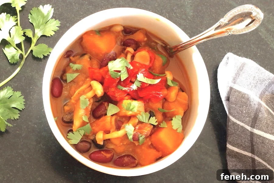 Hearty Vegan Butternut Squash Chili Recipe for Cozy Nights 2 Butternut Squash Chili in a bowl with sprig of cilantro t the side