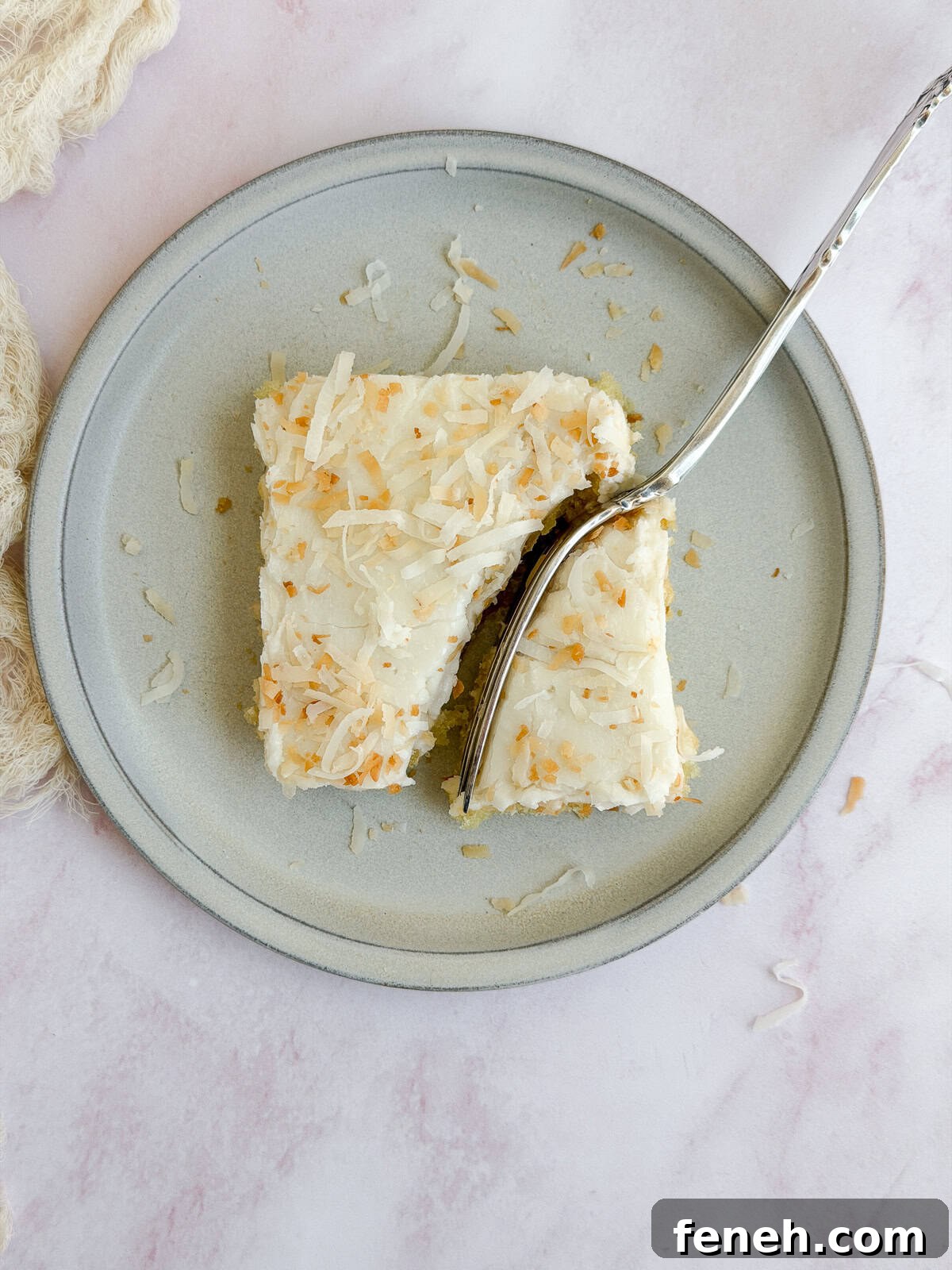 a fork cutting through a slice of coconut texas sheet cake.