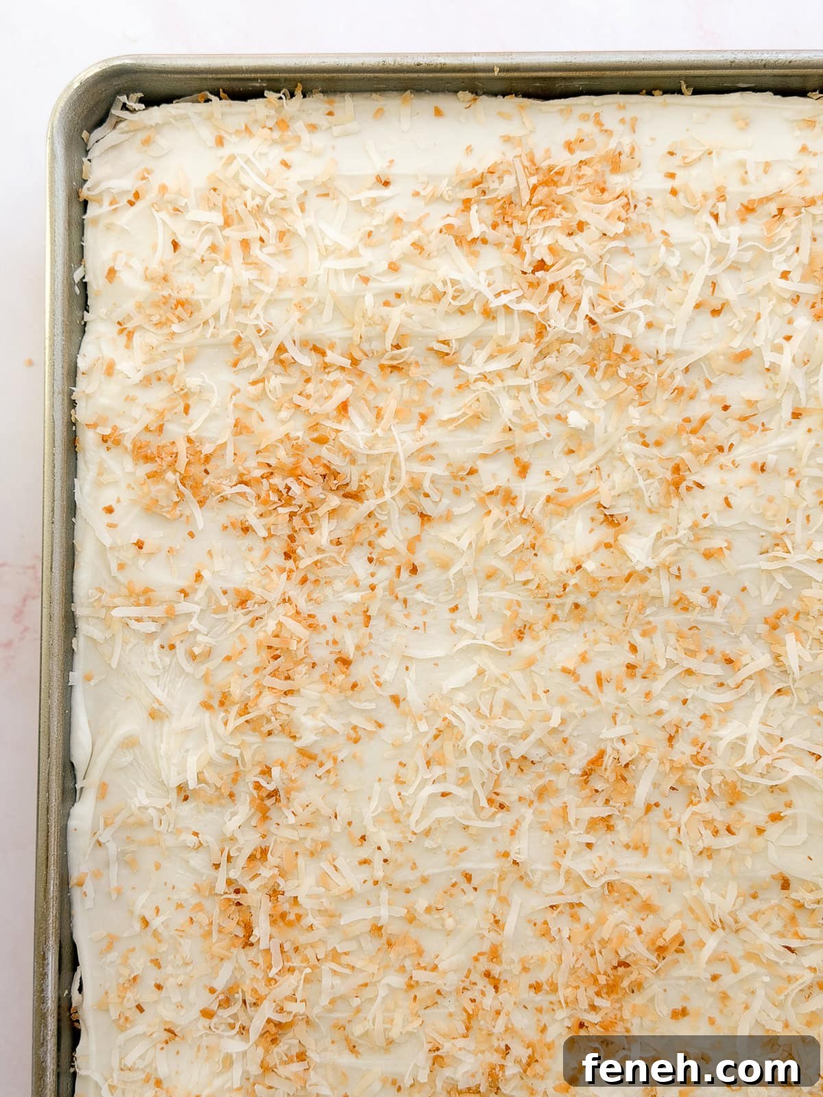 a close up of the coconut texas sheet cake in the pan before cutting.