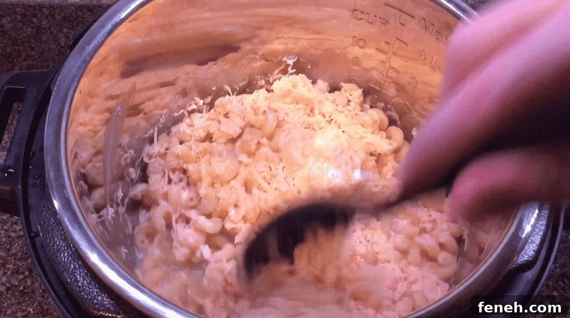 Stirring creamy mac and cheese sauce