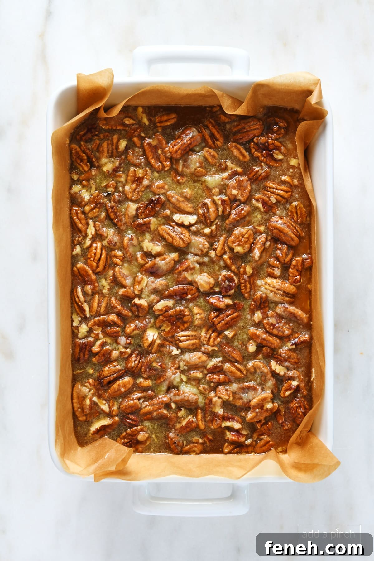 Unbaked pecan pie bars in a baking dish.