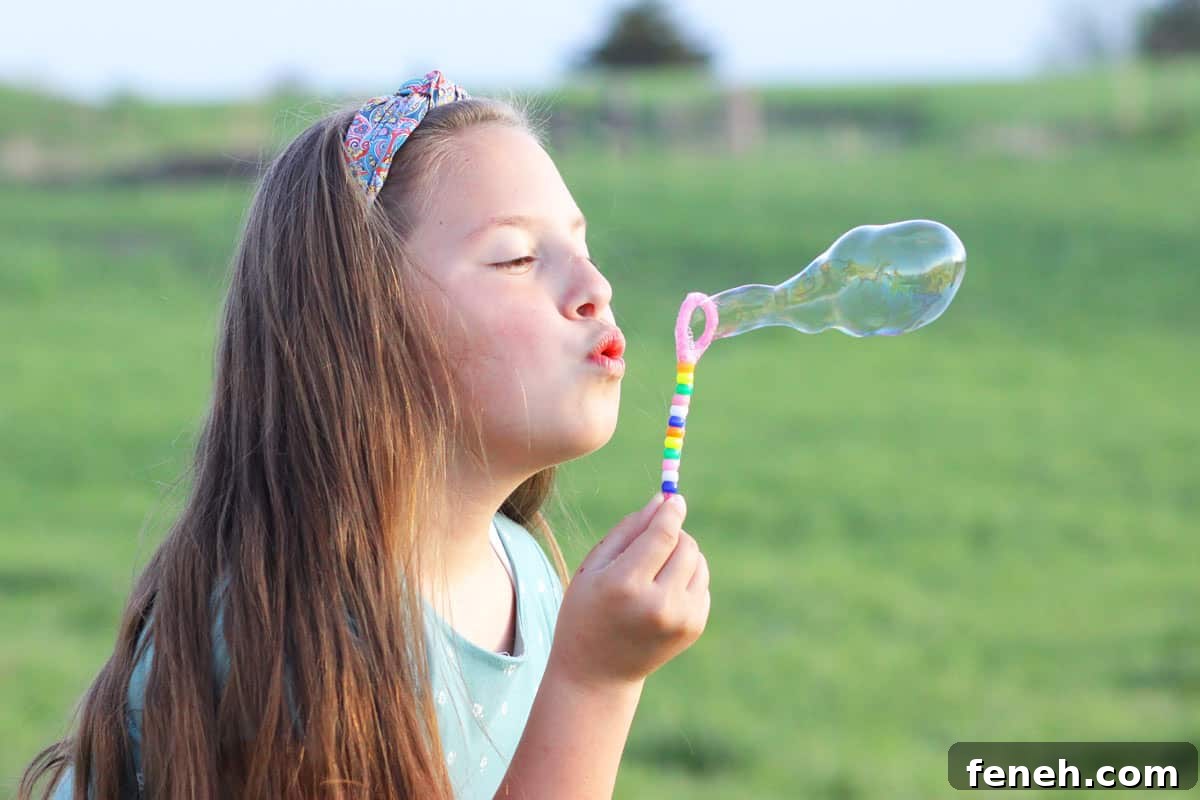 a girl blowing bubbles with a homemade bubble wand