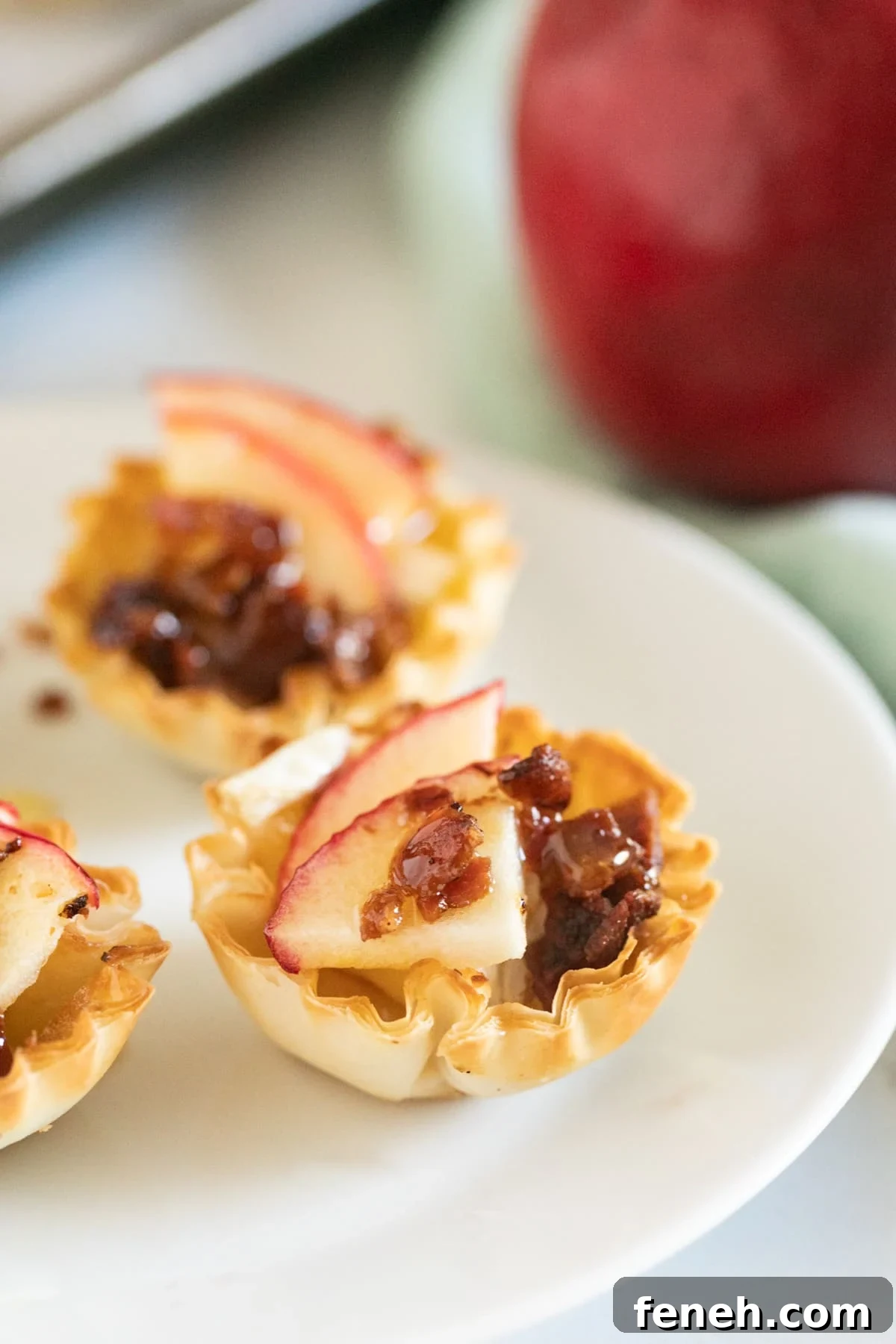 A close up of a baked brie bite on a white plate.