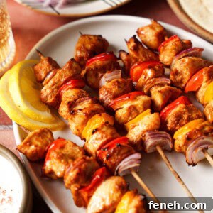 air fryer chicken kebabs or chicken skewers on a plate with lemon slices.