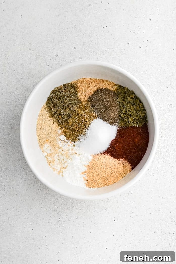 White bowl filled with breadcrumbs, cornstarch, and various seasoning and spices before being mixed together.