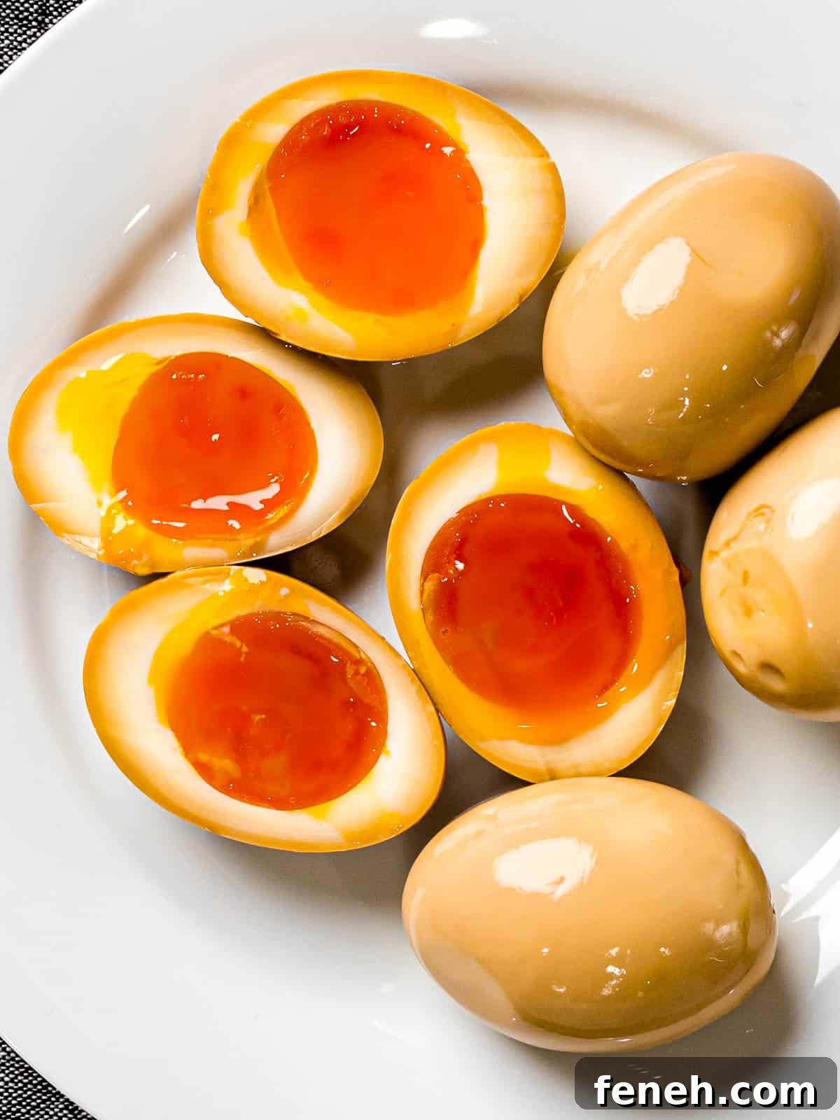 Soft boiled ramen eggs (ajitama) marinated in soy sauce and cut in half to show runny, jammy yolk.