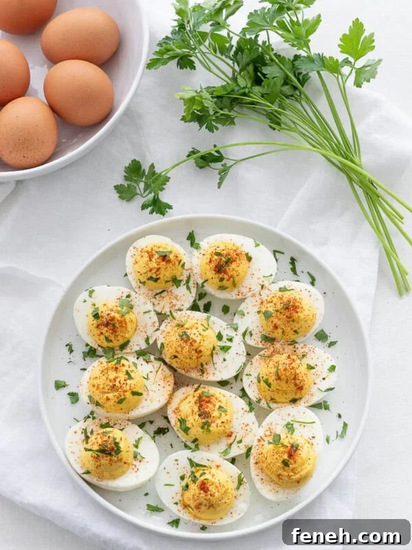 classic keto deviled eggs with parsley and paprika on a white plate