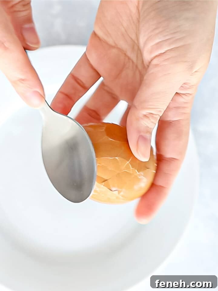 Tapping an egg shell with the back of a spoon to crack the shell.