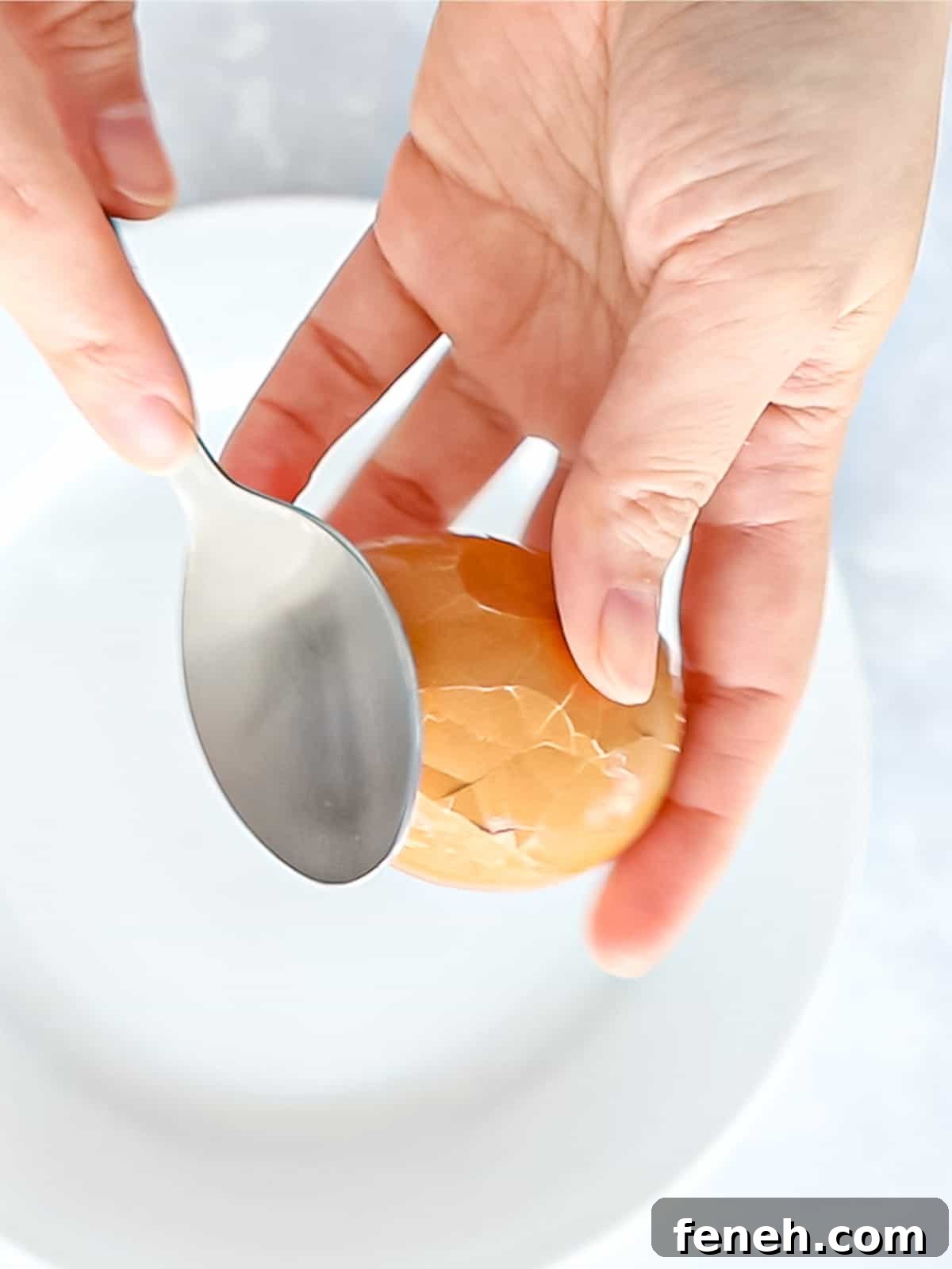 Tapping an egg shell with the back of a spoon to crack the shell.