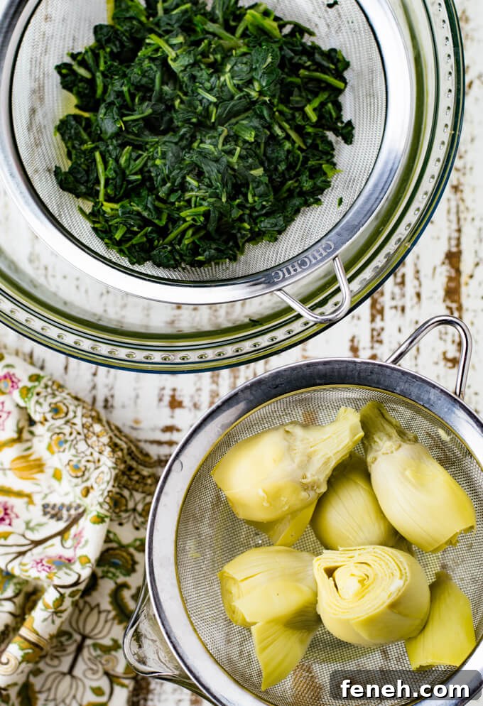 Two wire sieves, one holding thawed spinach and the other one holding canned artichokes. A tan, green and purple napkin sits next to them.