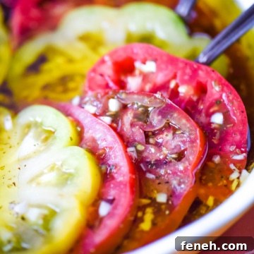 Closeup side view of marinated heirloom tomatoes in a pie dish.
