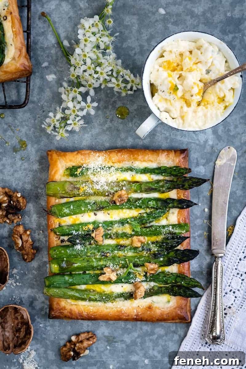 Puff pastry tart filled with cheese and topped with asparagus