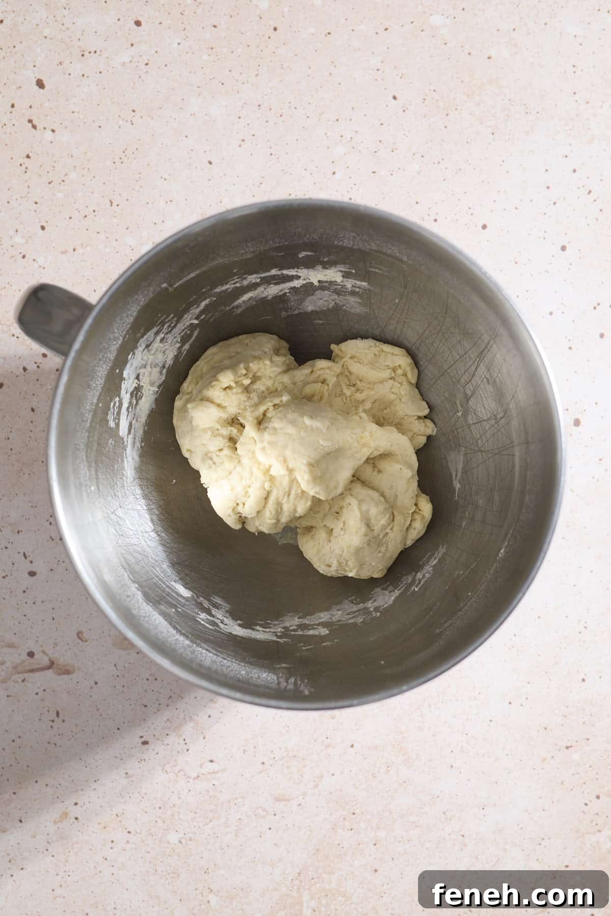 Dough in the bowl of a stand mixer.