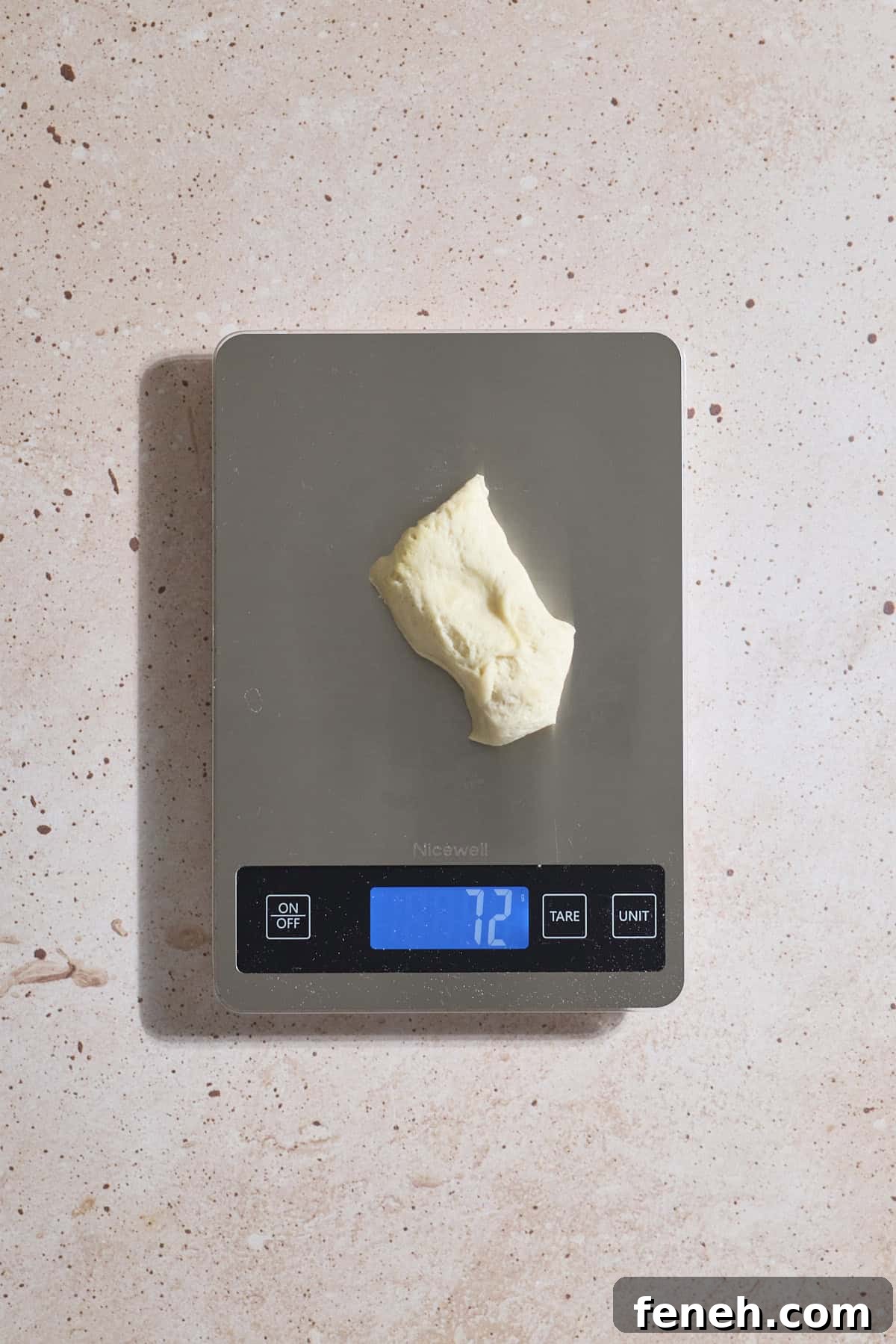 Dough being divided on a kitchen scale.