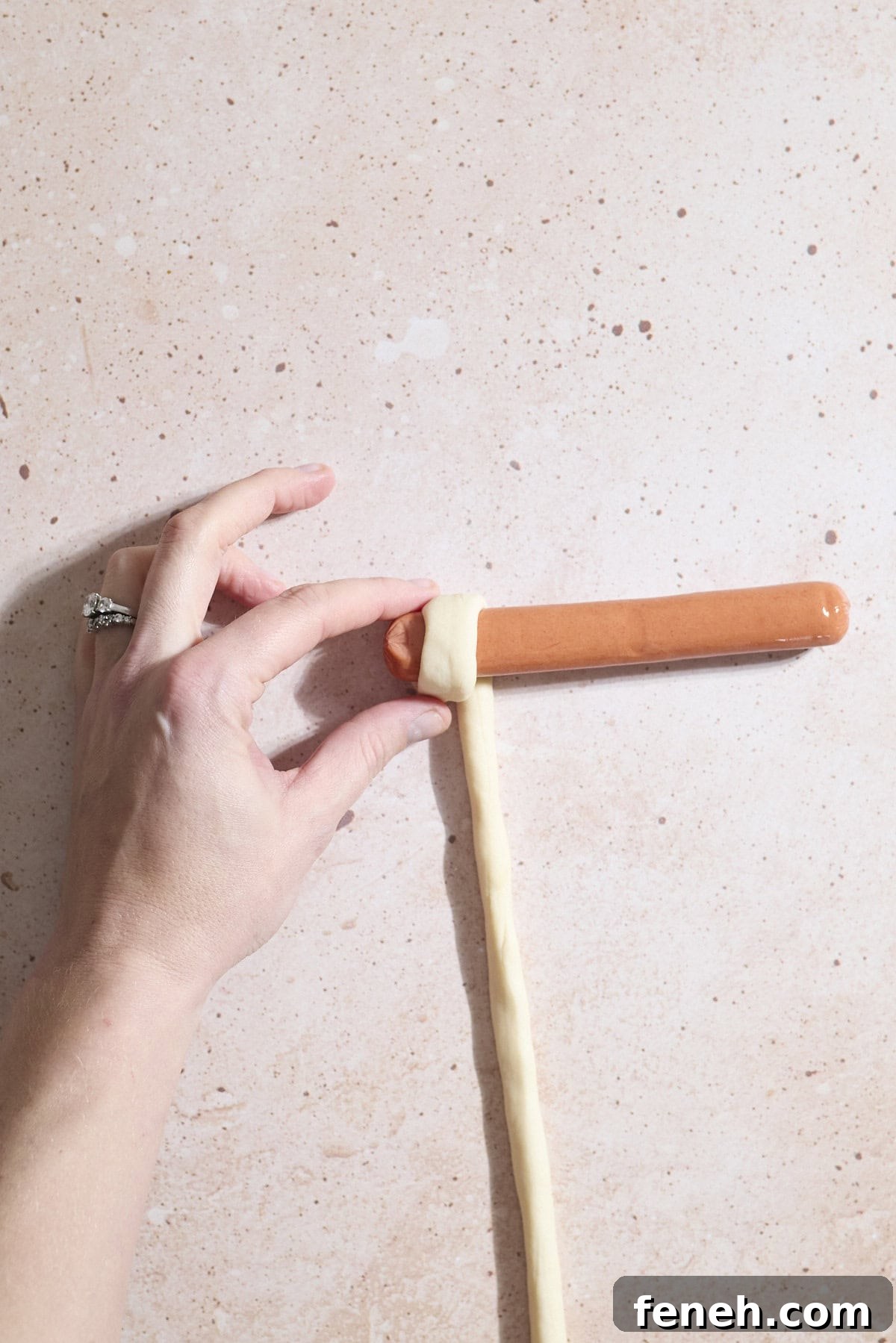 Dough at the start of wrapping around the hot dog.
