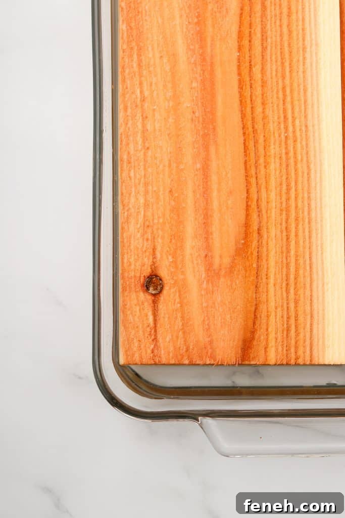 A close up of a cedar plank soaking in water