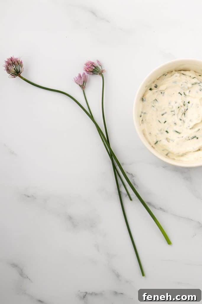 Creamy horseradish sauce in a bowl with fresh chive blossoms